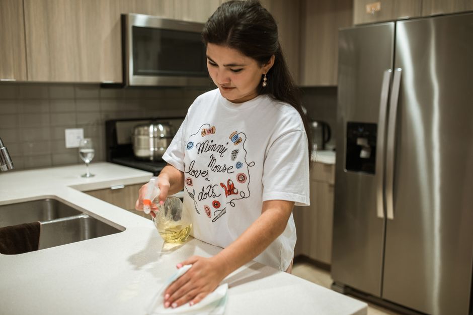 Professional wiping down a pristine kitchen counter
